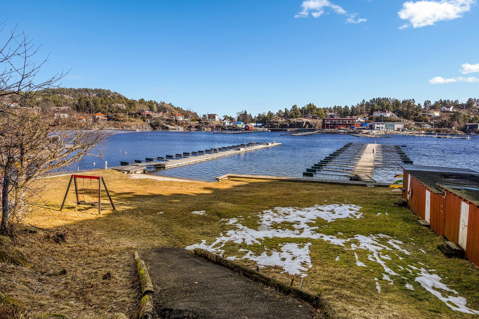 Nede ved sjøen er det båtplass i felles bryggeanlegg og egen sjøbod i byggene du ser til høyre. Galleribilde