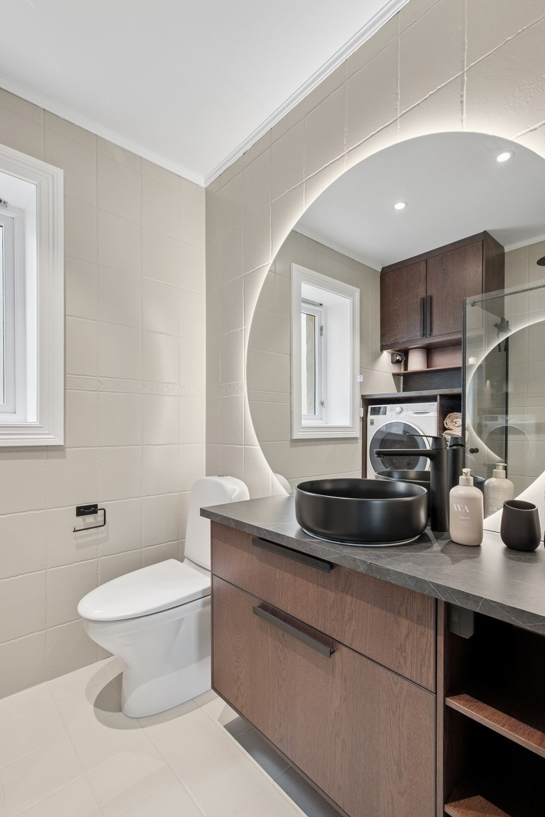 Baderommet er utstyrt med gulvstående klosett, dusjhjørne med svingdører og en toppmontert servant med praktisk servantinnredning. Galleribilde