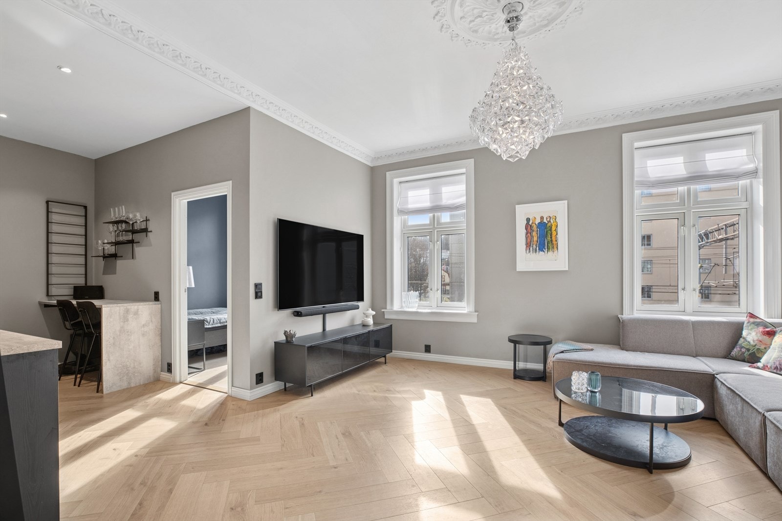 Stuen byr på klassiske detaljer som stukkatur og rosett i himlingen, samt lekkert fiskebensparkett på gulvet fra 2023. Det er varmefolie under gulvet. Galleribilde