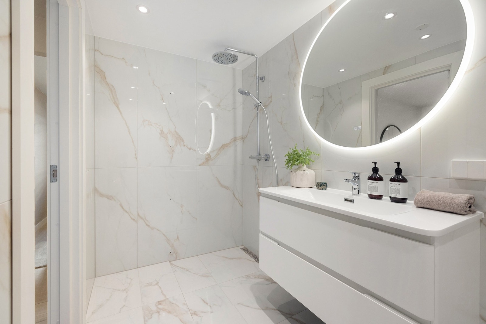 Dette elegant badet med egen vaskeromsdel ble totalrenovert i 2025 og kombinerer moderne design med praktiske løsninger. Galleribilde