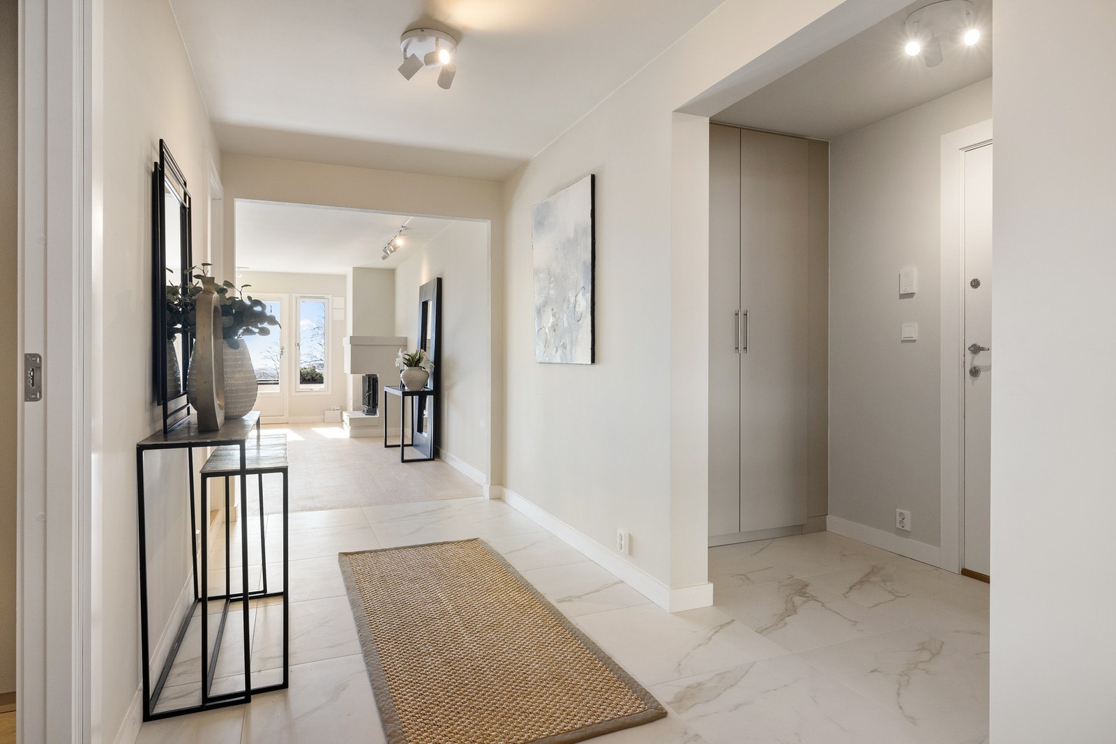 Elegant og lys entré/gang med innebygde garderobeskap, hvor detaljene er nøye gjennomtenkt, blant annet med elegante garderobehåndtak fra R. Bergersen. Galleribilde