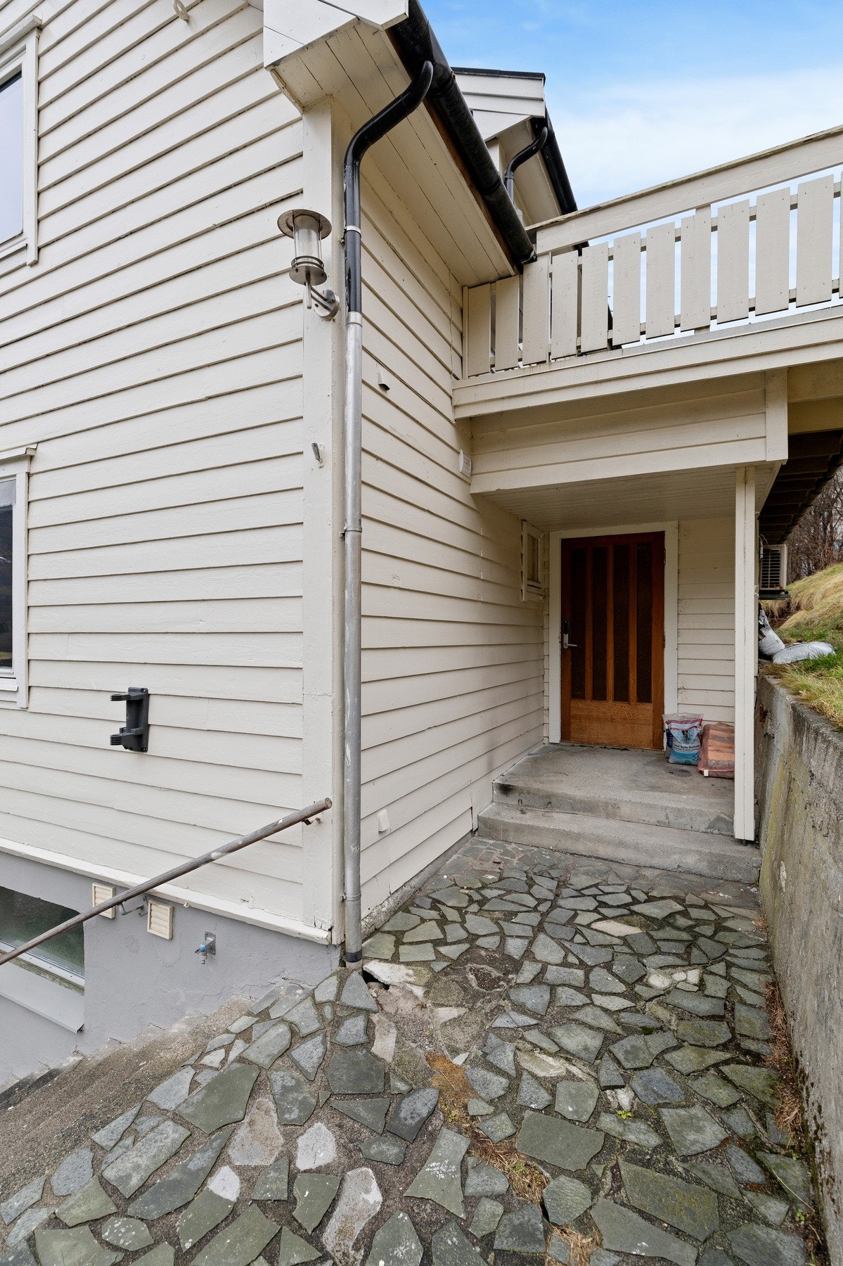 Hovedetasjens inngangsparti ligger på baksiden av boligen. Leiligheten i hovedetasje og loftsetasje er idag utleid for kr. 9 300,- per måned. Galleribilde