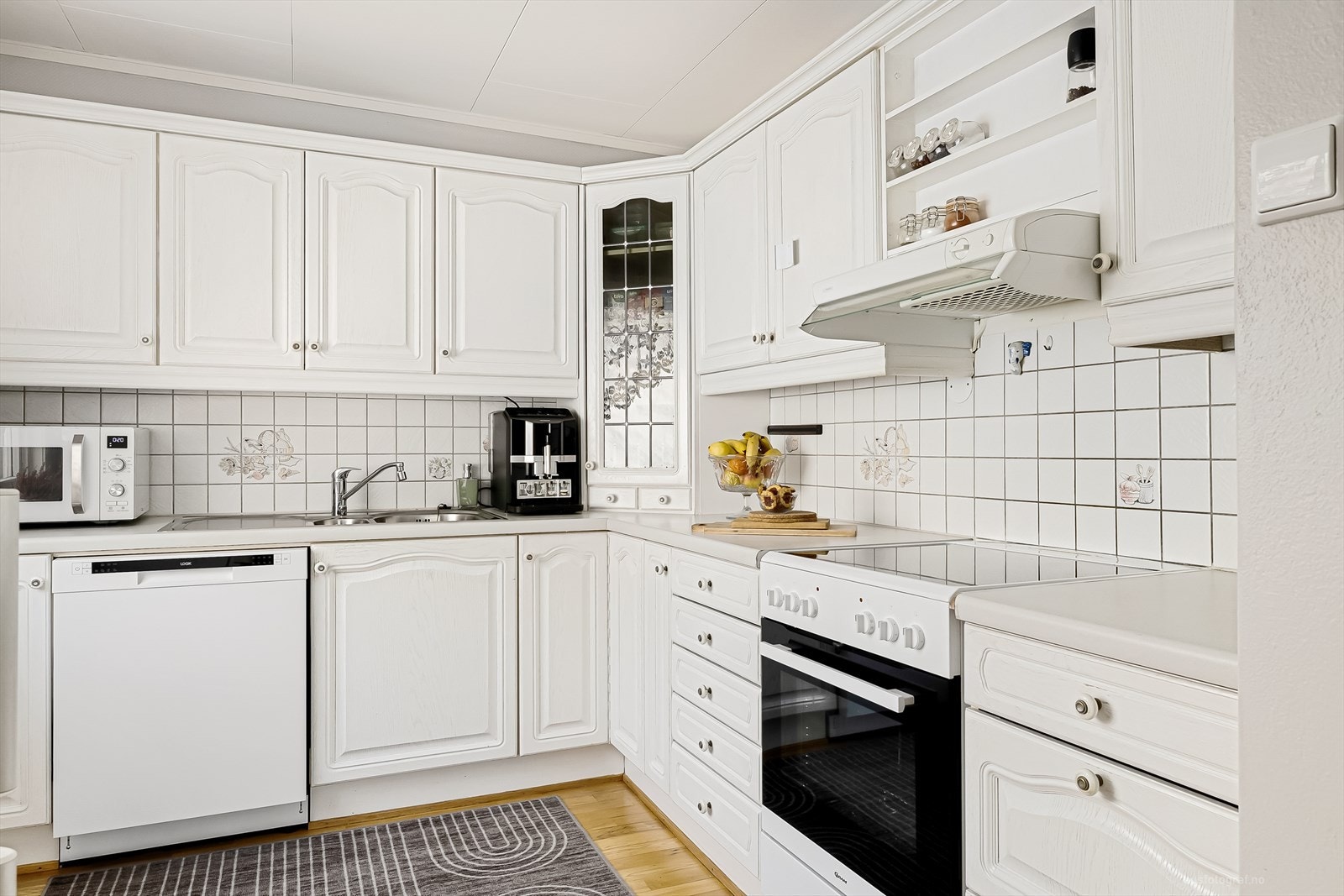 Veggen over benkeplaten er flissatt og det er mye oppbevaringsplass i de takhøye skapene Galleribilde