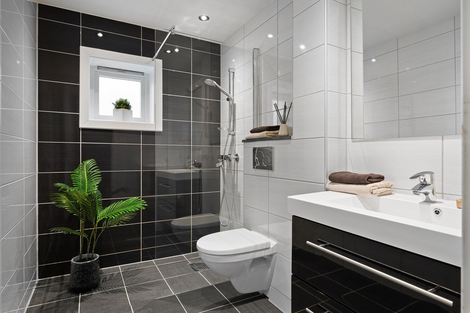 Helfliset bad fra 2013 innredet med praktisk dusjhjørne og vegghengt toalett. Galleribilde