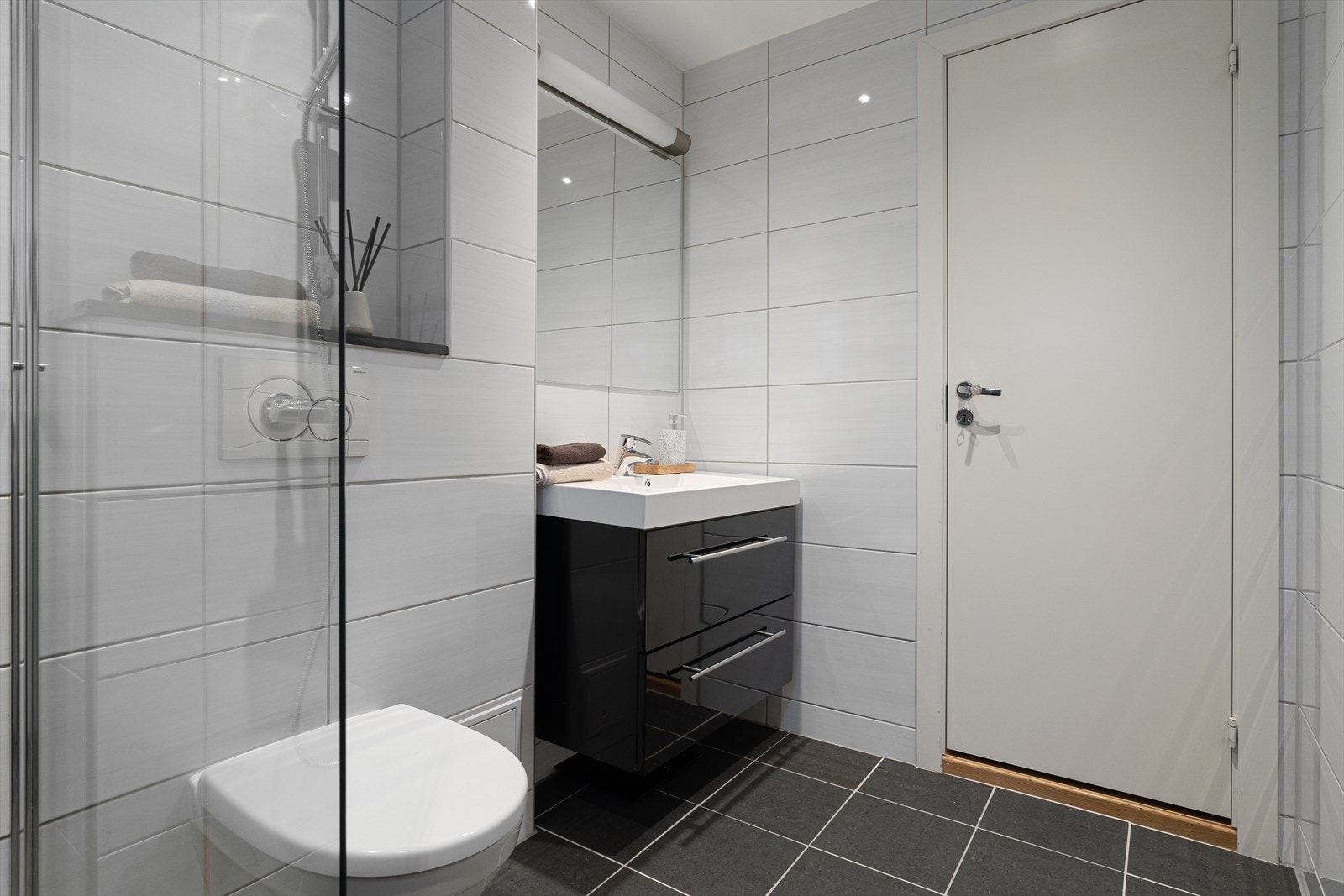 Videre er det vegghengt møbel med servant, og speil med belysning. Galleribilde