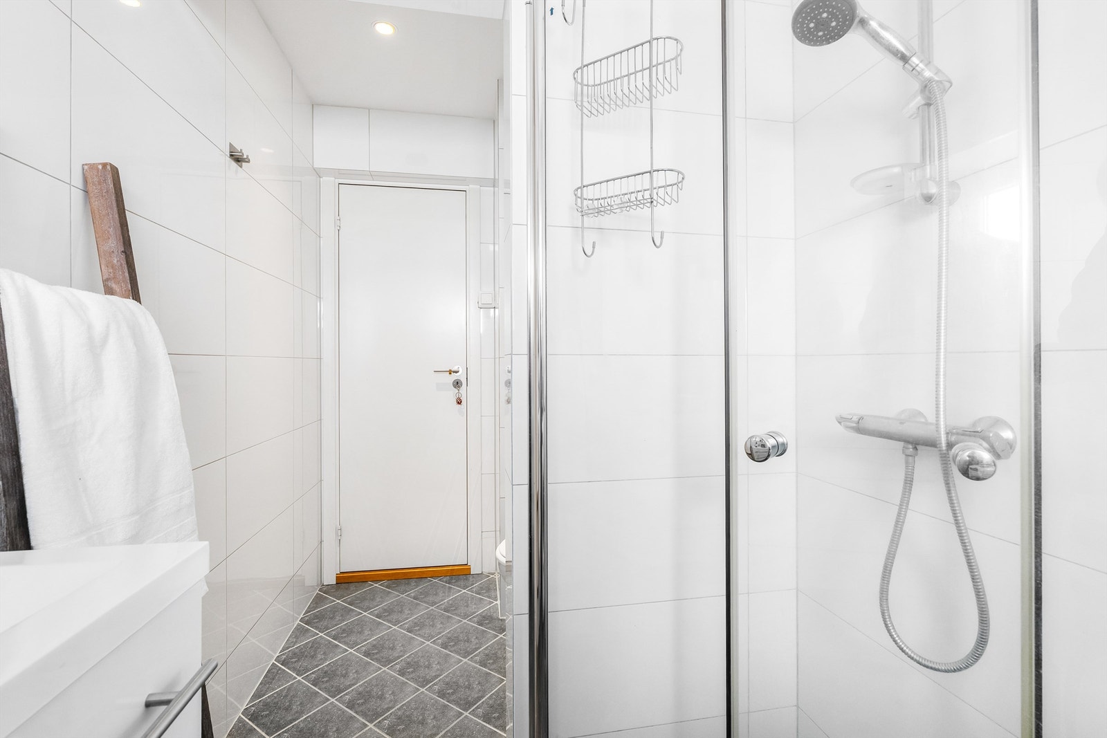 Dusjhjørnet har dører og vegghengt dusjarmatur Galleribilde