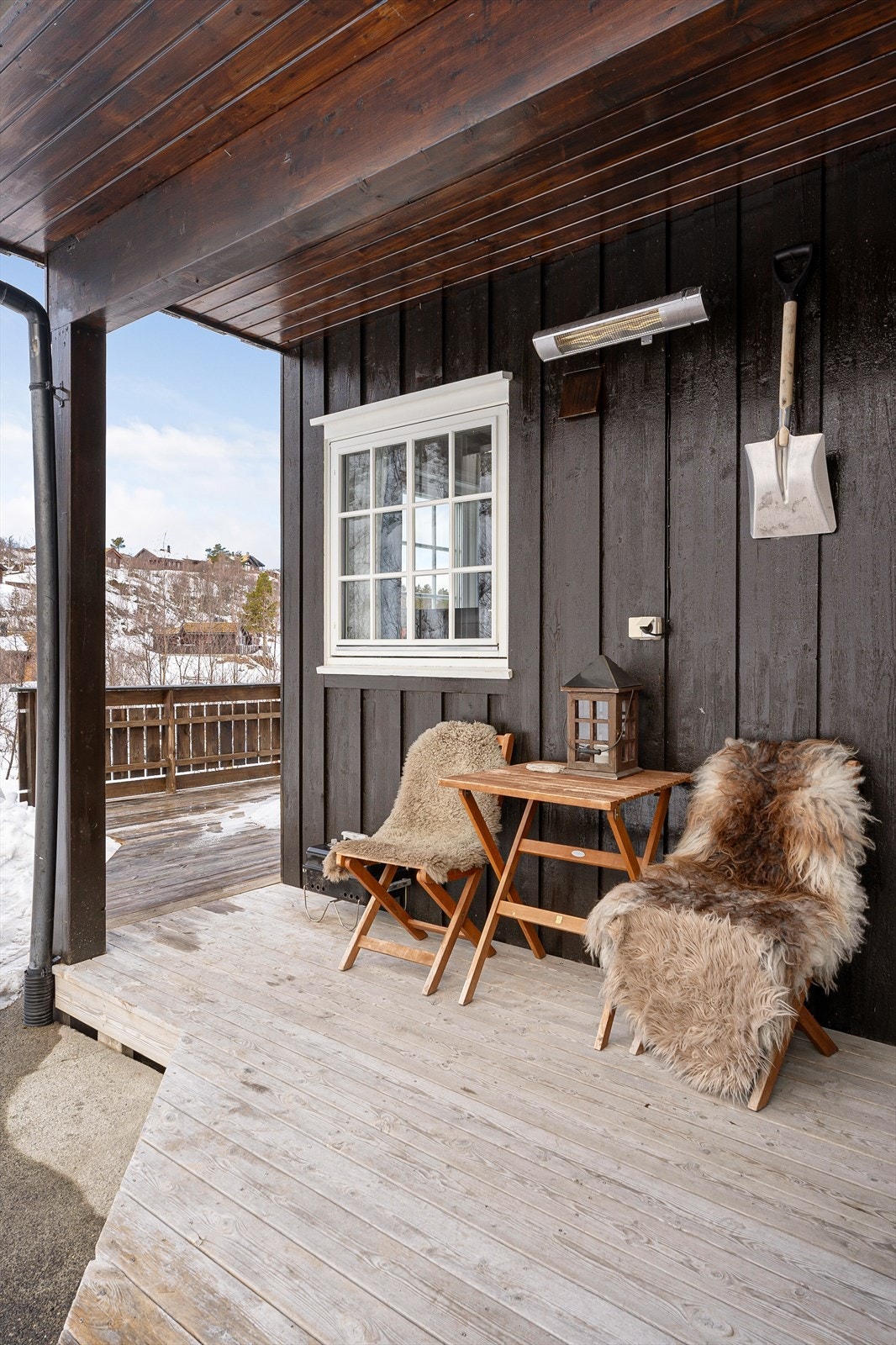 Plass til sittegruppe, potteplanter og lykter. Terrassen strekker seg videre rundt deler av hytta. Galleribilde