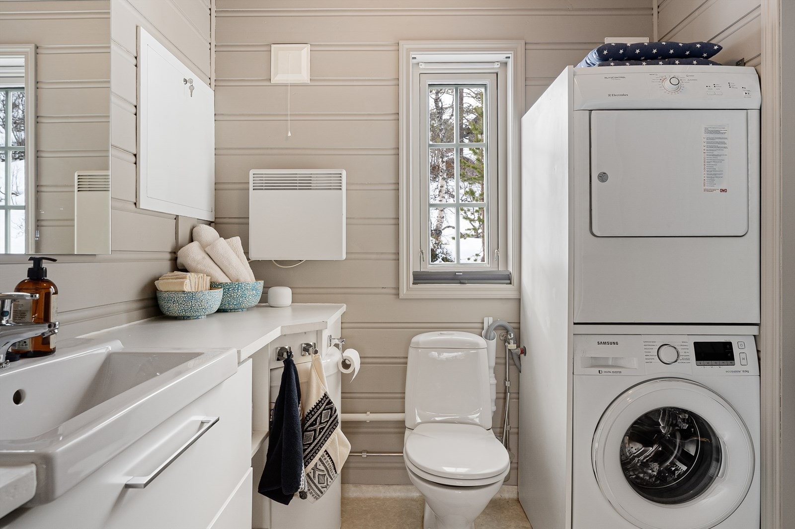 I tillegg har hytten et separat vaskerom/WC (opprinnelig byggemeldt som bod) med bi-inngang. Rommet er innredet med gulvstående wc, baderomsinnredning med servant, samt opplegg/plass for vaskemaskin. Det er også plass til tørketrommel. Galleribilde