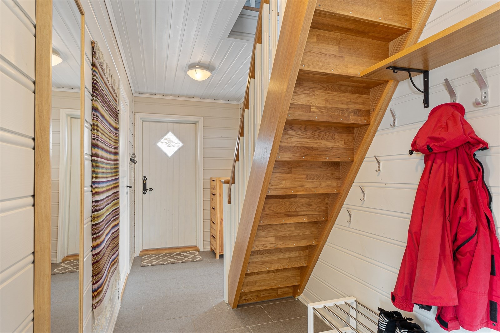 Entréen/gangen gir et fint førsteinntrykk. Her er god plass til yttertøy og sko. Fra gangen er det en flott trapp opp til hemsen.
Gulvet i entré/gang er flislagt (fornyet i 2017). Varmekabler i gulvet sørger for en lun velkomst. Galleribilde
