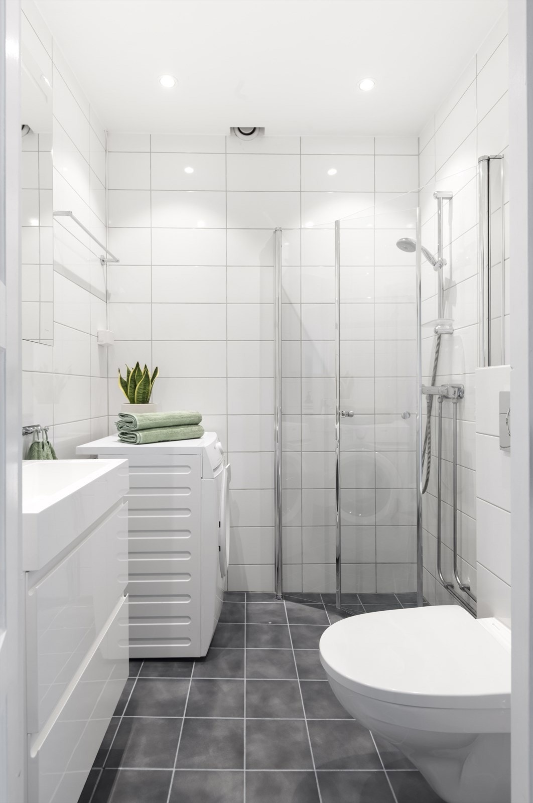 Badet fra 2017 med flissatte overflater i innbydende farger, samt varme i gulv og downlights i himling. Galleribilde