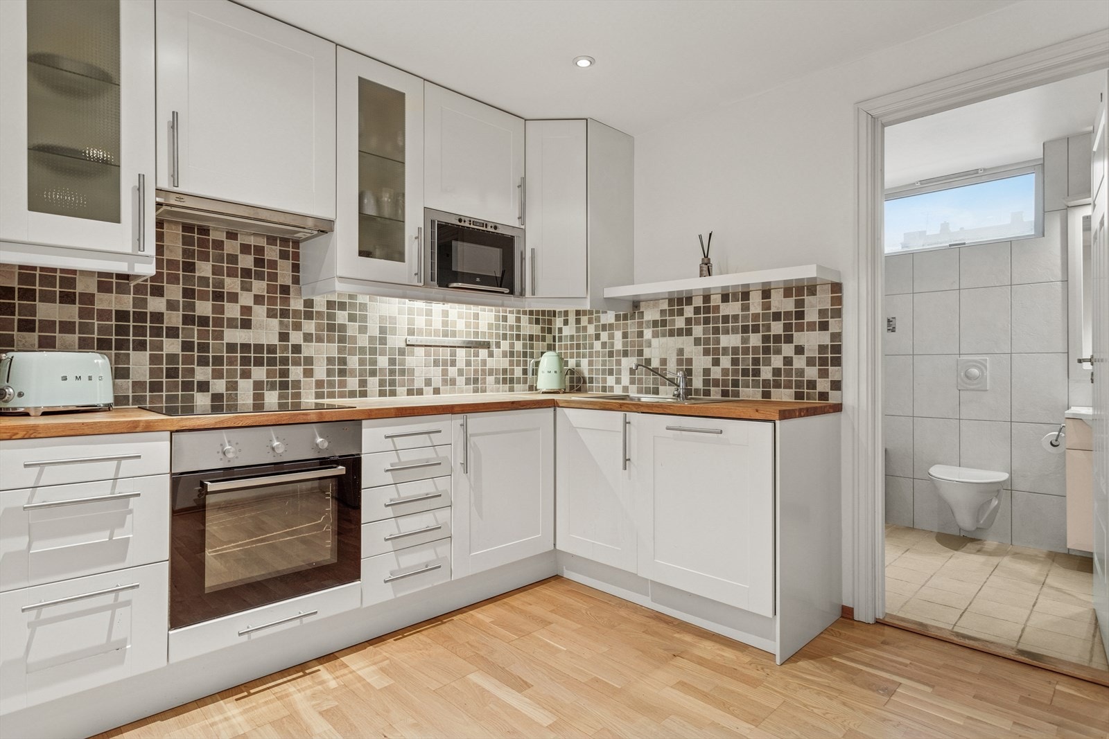 Romslig kjøkken med mye oppbevaringsplass i skuffer og skap. Kjøkkenet nyter godt av god benkeplass som gir god arbeidsplass Galleribilde