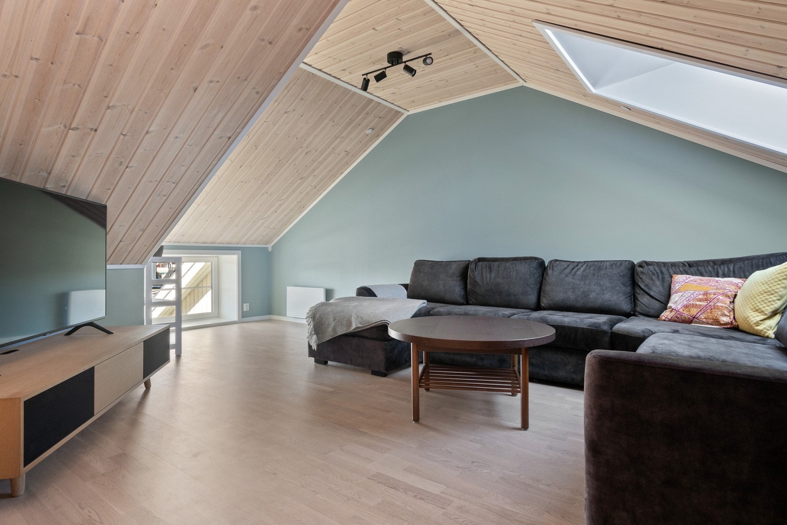 I loftsetasjen finner man en hyggelig stue med takvindu, parkettgulv og grønnmalte veggflater. Galleribilde