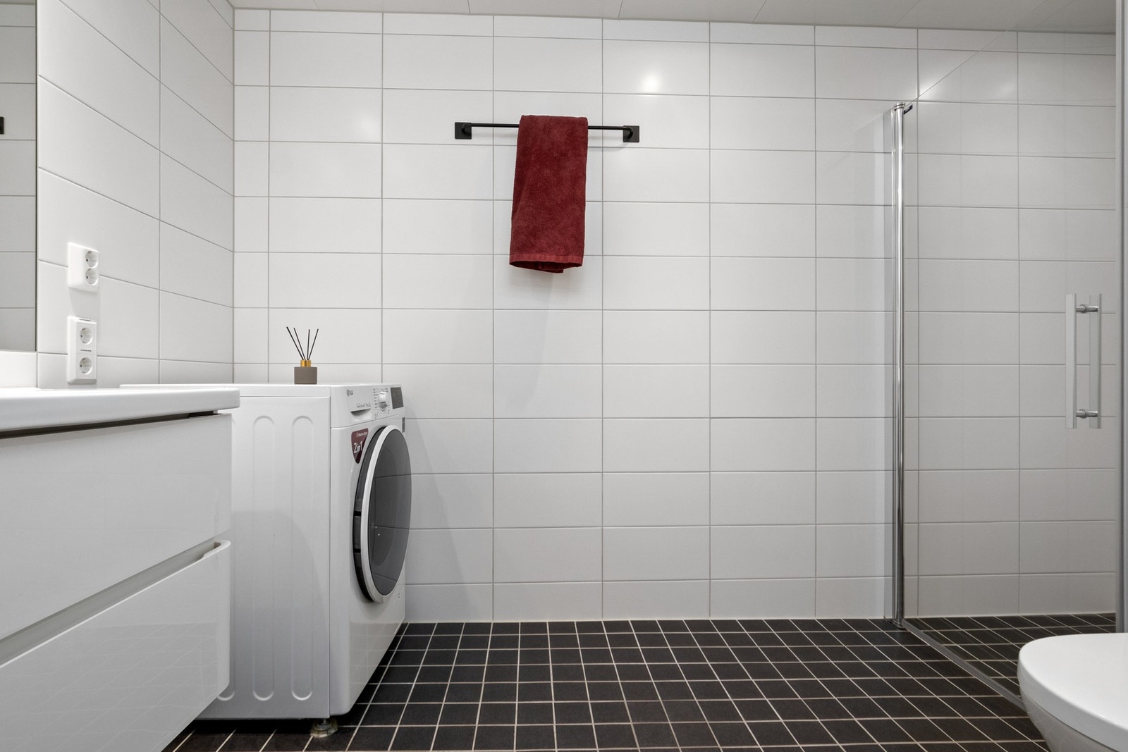 Baderomsinnredningen består av et speil og en servant med hvite skuffer. Galleribilde