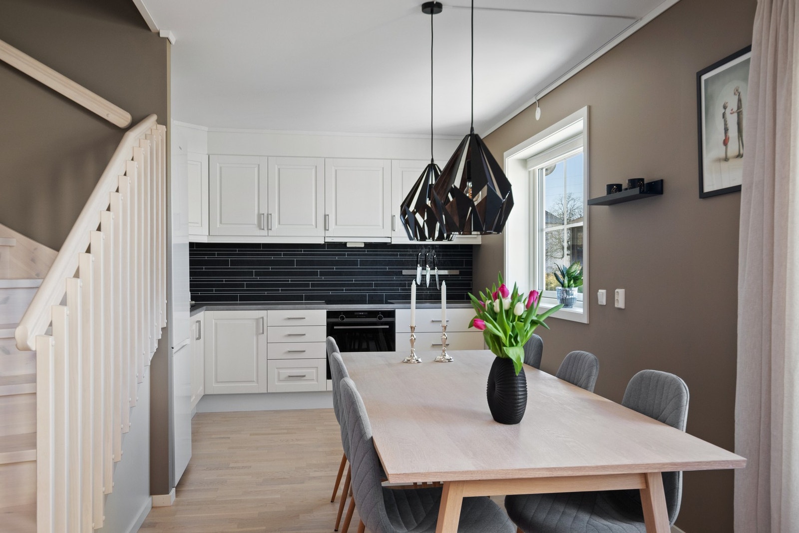 Kjøkkeninnredningen er tidløs med hvite, profilerte fronter, laminatbenkeplate og nedfeldt oppvaskkum. Galleribilde