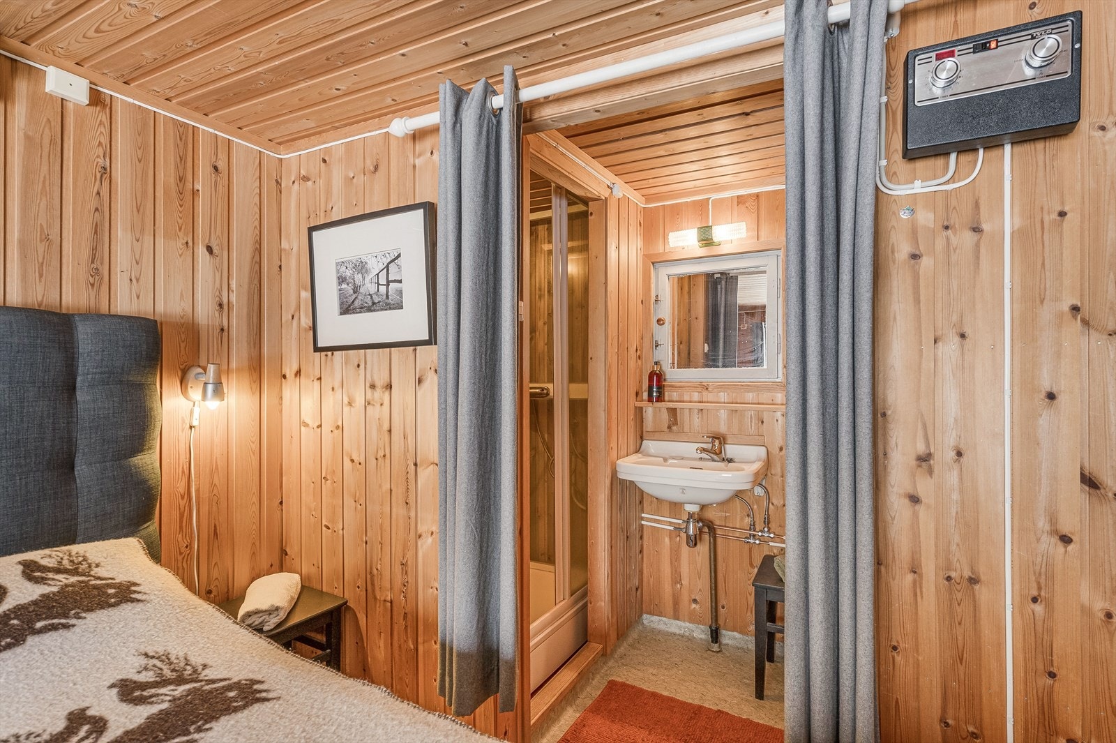 Badet er innredet med vegghengt servant, belyst speil og dusjkabinett i nisje. Galleribilde