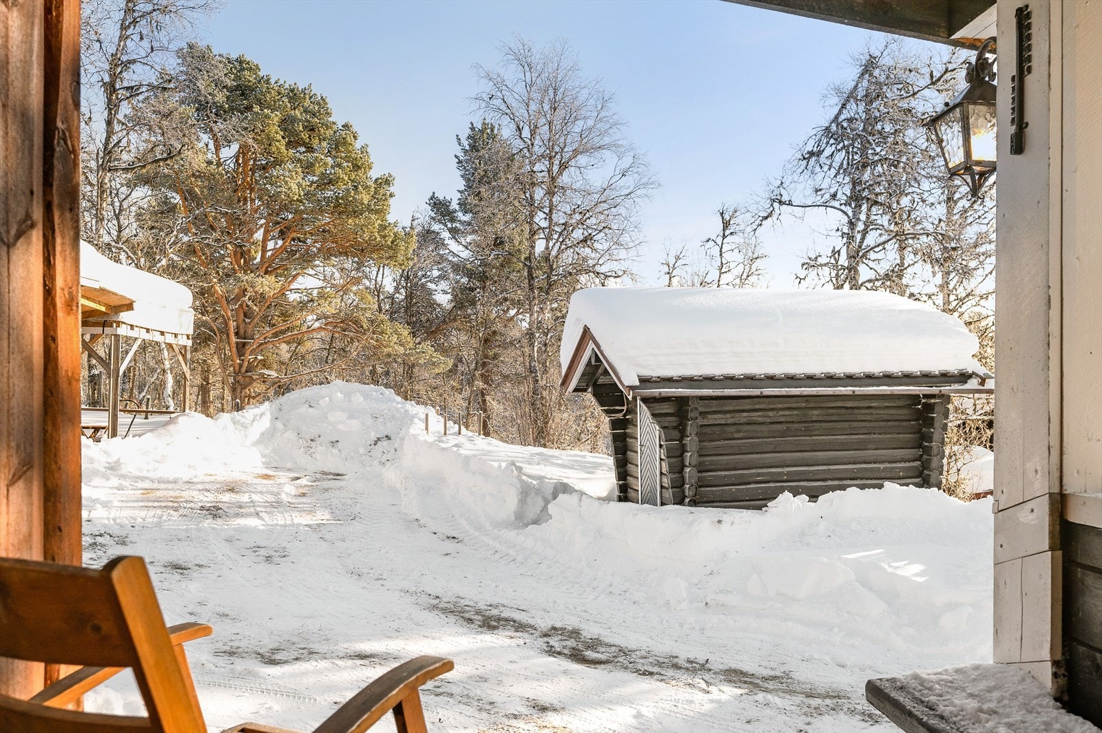 Utsyn fra inngangspartiet mot tunet, hvor det bl.a. står et frittstående anneks i tømmer. Galleribilde