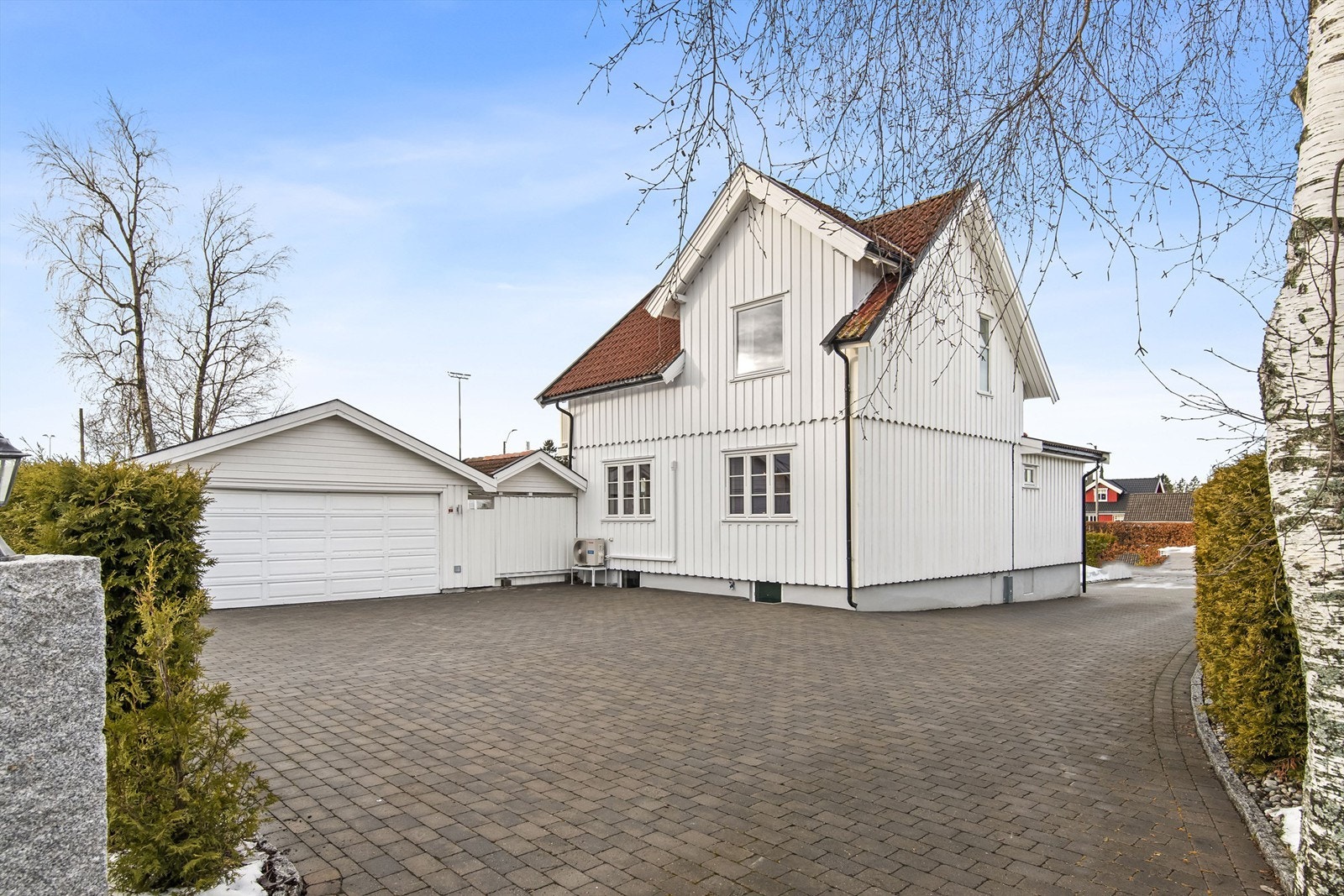 Stensatt gårdsplass og dobbelgarasje med elbil lader som medfølger Galleribilde