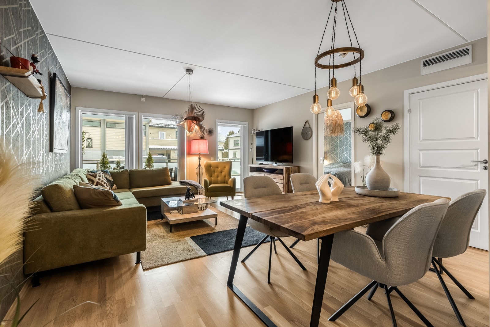 Veggene i allrommet er malt opp i en pen beigetone, og én vegg er kledd med en tidsmessig tapet. Galleribilde