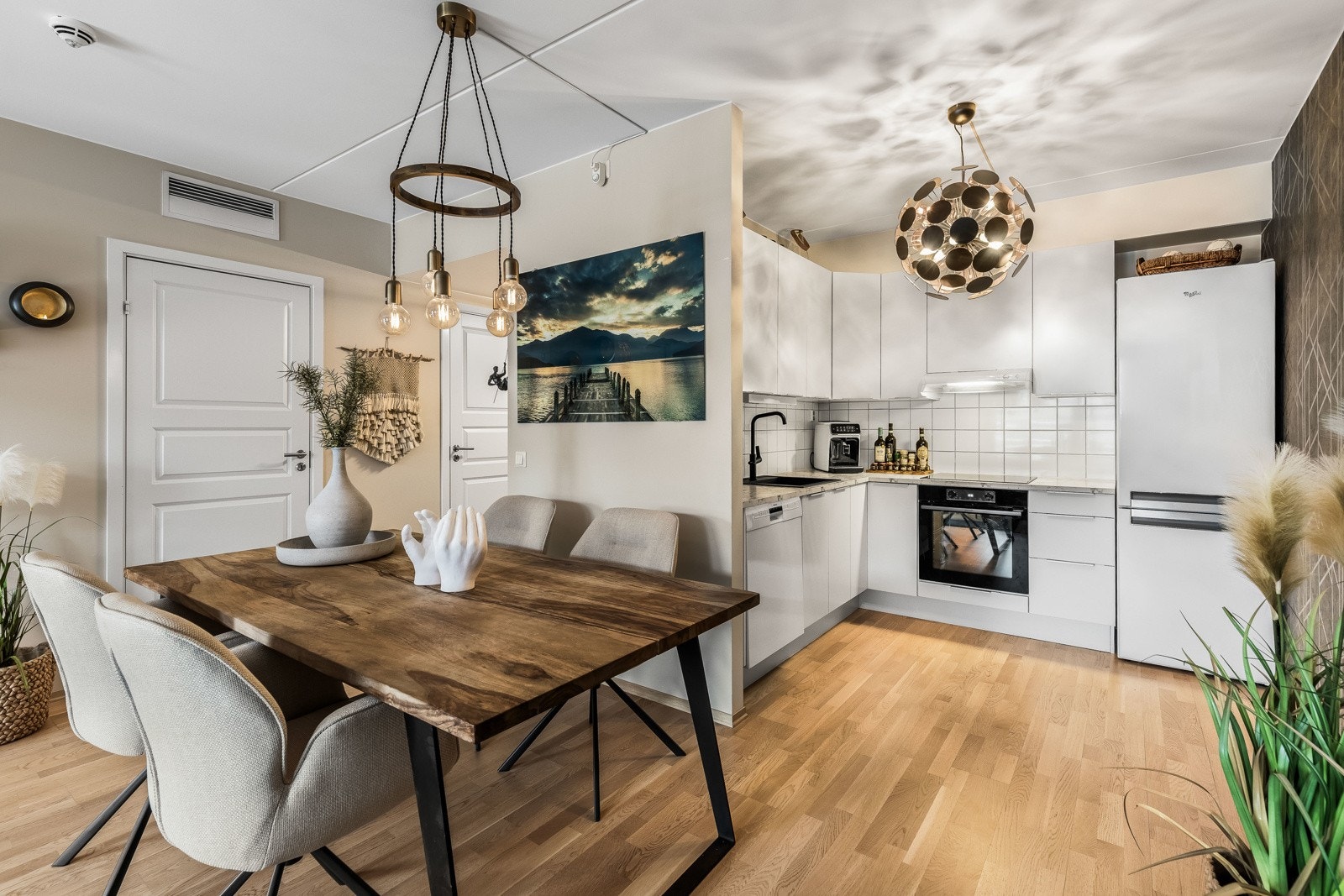 Kjøkkenet har et stilrent og pent design med gode benkeflater og rikelig med oppbevaringsplass. Innredningen fra Norema har hvite, glatte fronter og lys laminatbenkeplate med nedfelt, sort oppvaskkum. Galleribilde