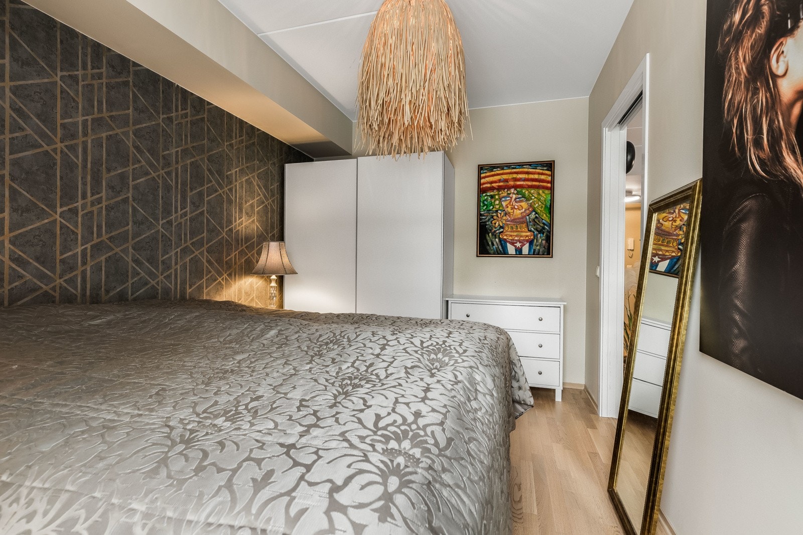 Veggene er malt opp i en dus beigetone som står godt til parkettgulvet, og én vegg er kledd med en tidsmessig tapet i fin kontrast. Galleribilde