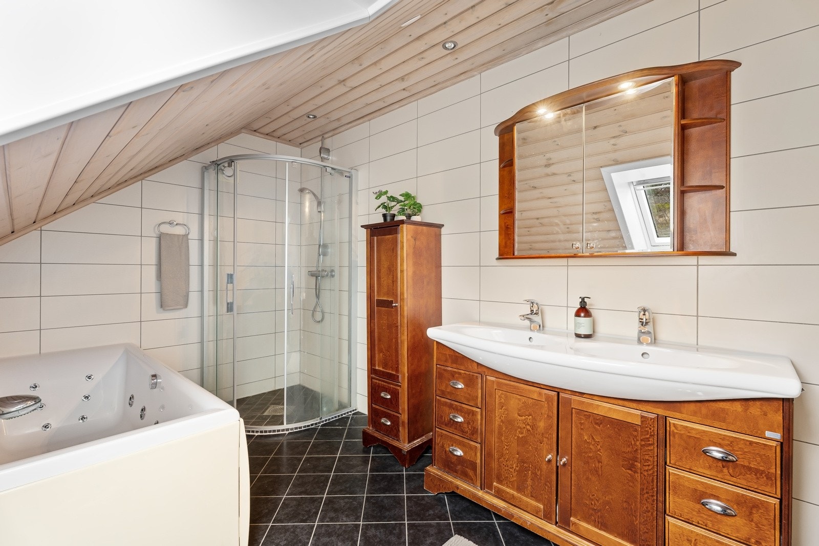 Badet er godt innredet med servantskap, dusjhjørne og badekar. Galleribilde