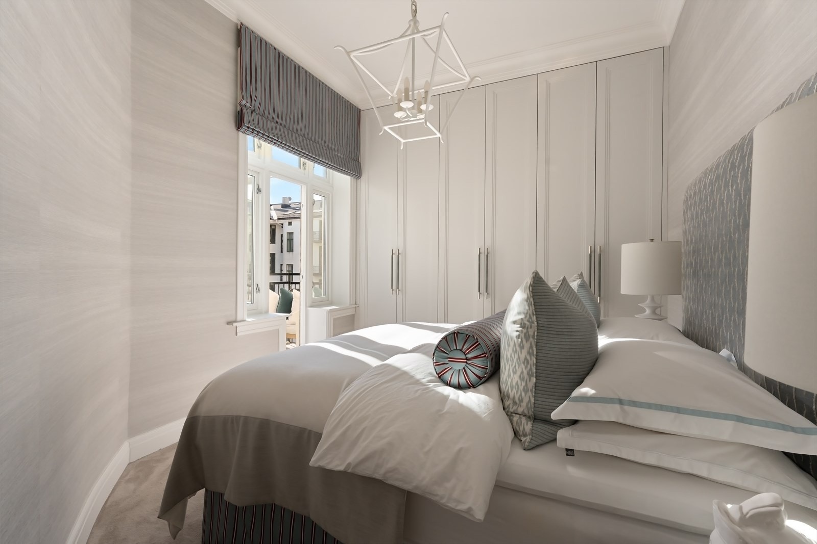 Garderobe med full takhøyde, vegg til vegg teppe på gulvet og lekker tapet på veggen. Galleribilde