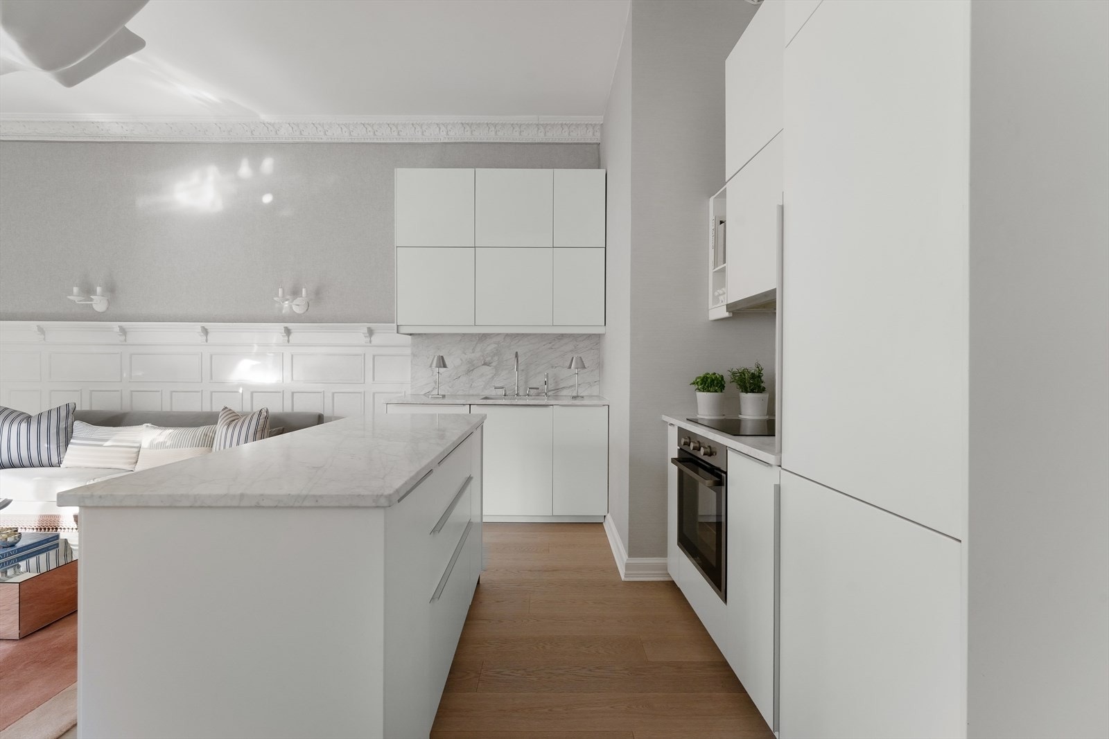 Slett hvitt kjøkken med integrerte hvitevarer og Calecatta marmor benkeplate Galleribilde