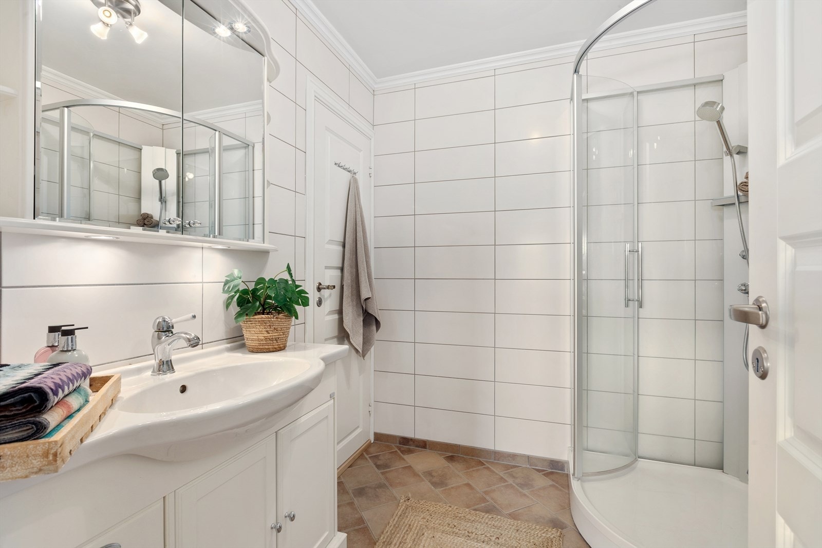 Badet er utstyrt med innredning med nedfelt servant, dusjkabinett, utslagsvask og opplegg for vaskemaskin/tørketrommel Galleribilde