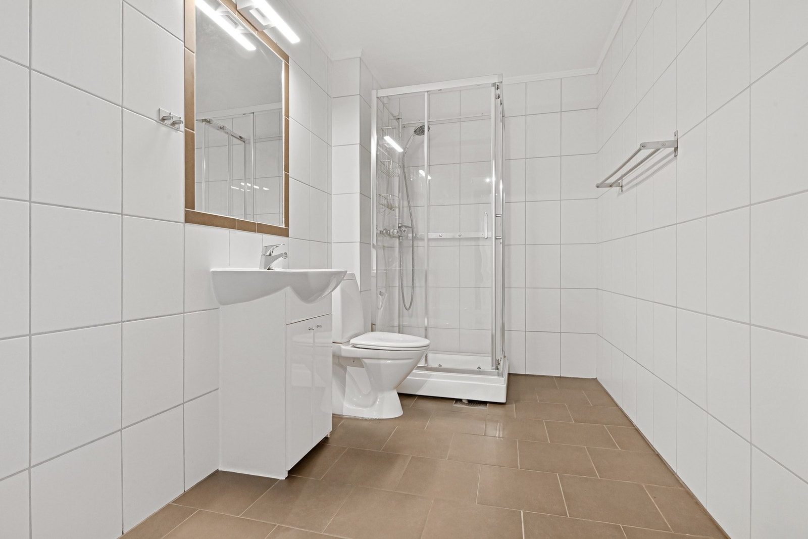 Leiligheten har et praktisk bad, og fungerer i tillegg utmerket som vaskerom. Badet er innredet med servantskap, speil på vegg, gulvfestet wc og dusjkabinett. Det er opplegg for vaskemaskin og plass til tørketrommel. Galleribilde