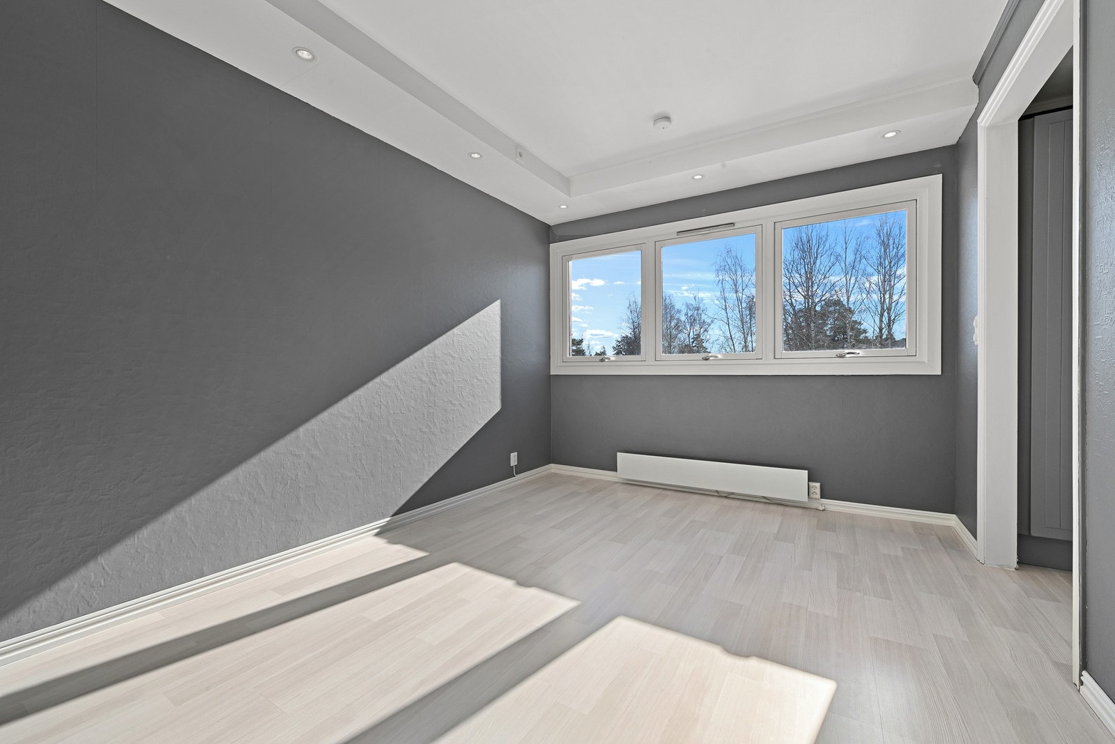 Rommet er lyst og innbydende, med plass til spisestuen ved vinduene. Galleribilde