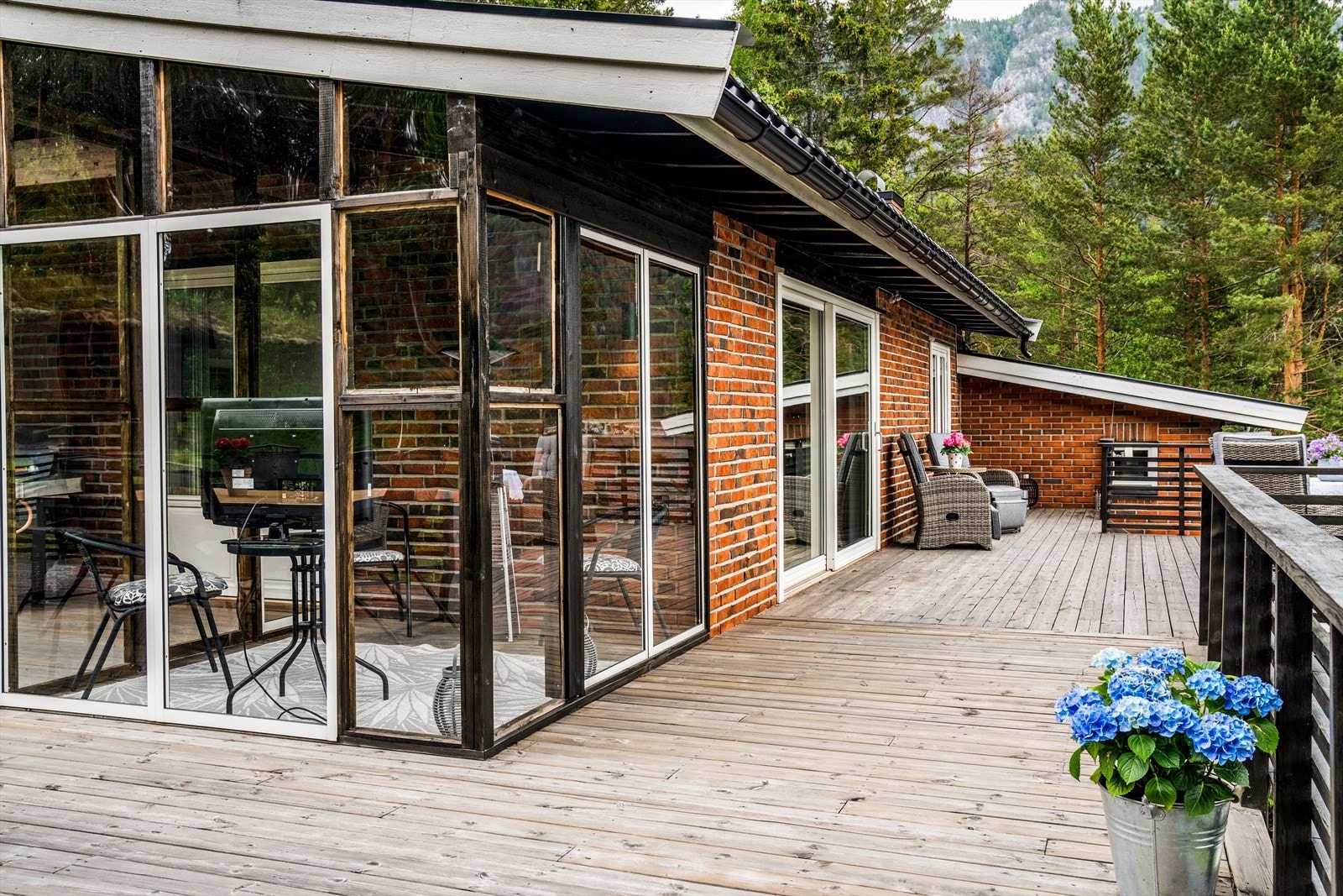 Verandaen er romslig, og strekker seg langs flere av boligens yttervegger, samt over to nivåer som fint bindes sammen med en tretrapp. Verandaen er solrik og her kan du flytte deg med solen i løpet av dagen. Galleribilde