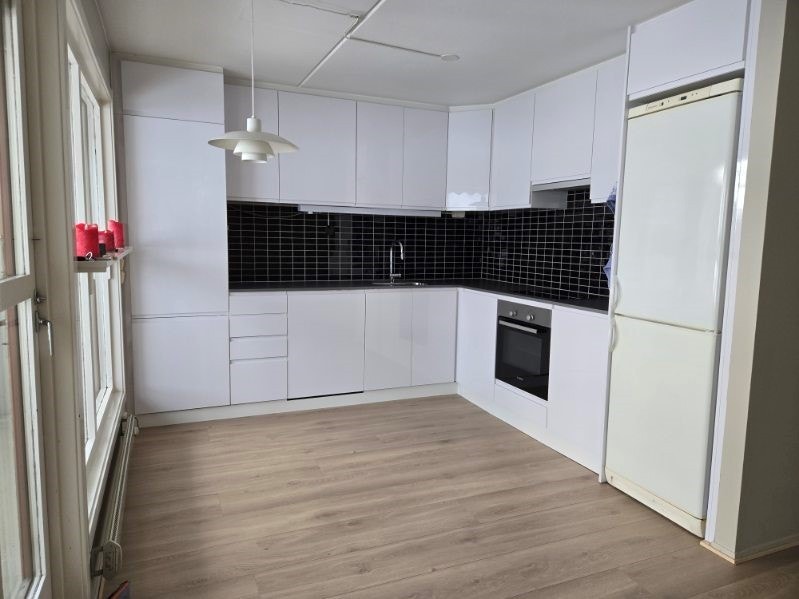 Pent kjøkken med integrete hvitevarer samt frittstående kjølfrys. Galleribilde