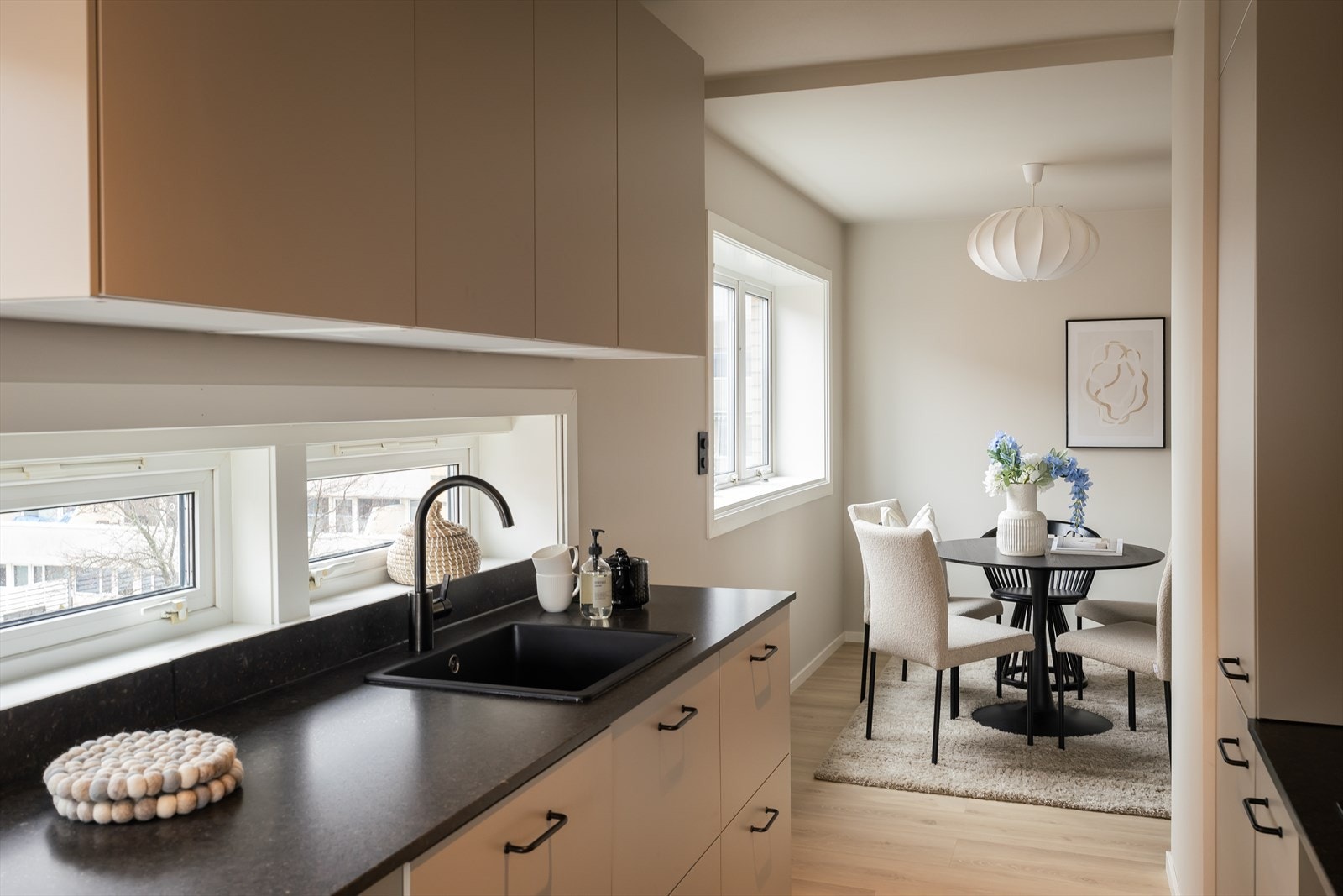 Det at leiligheten har en hjørnebeliggenhet gjør at man han vindu under overskapene på kjøkenet som gir godt med naturlig lysinnslipp. Galleribilde