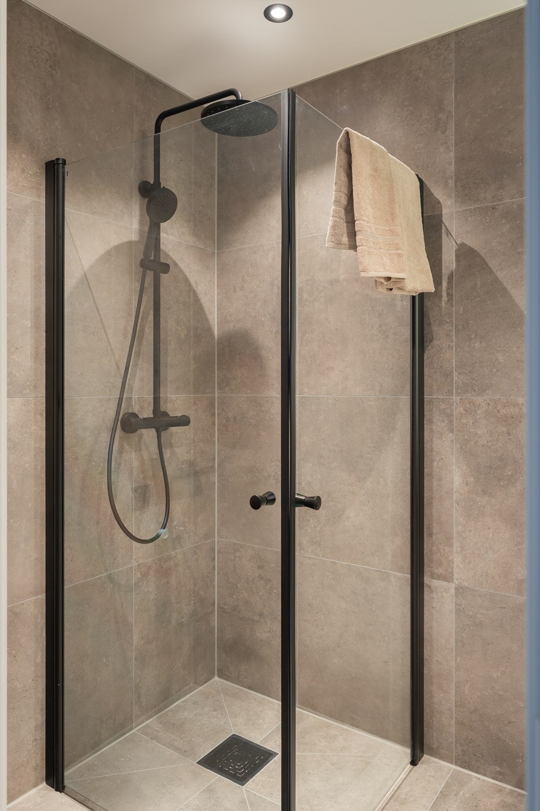 Badet består av sorte dusjdører med waterfall dusj, opplegg for vaskemaskin, 100 sort kommode, dimbar belysning i speil, og varmekabler i gulv. Galleribilde