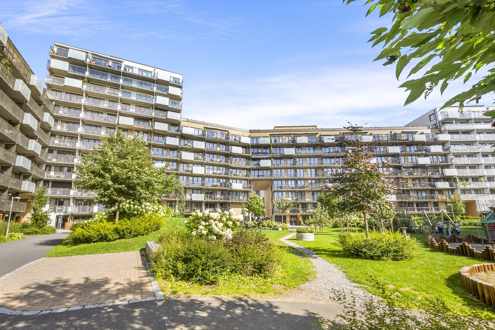 Det er et bilfritt indre gårdsrom, som er pent opparbeidet med asfalterte internveier, benker, trær og busker. Galleribilde