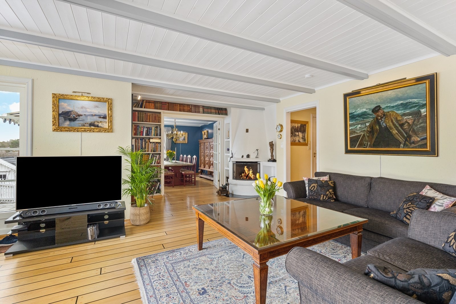 Stuen har skipsgulv i heltre eik, synlige trebjelker og peis med innsats. Galleribilde