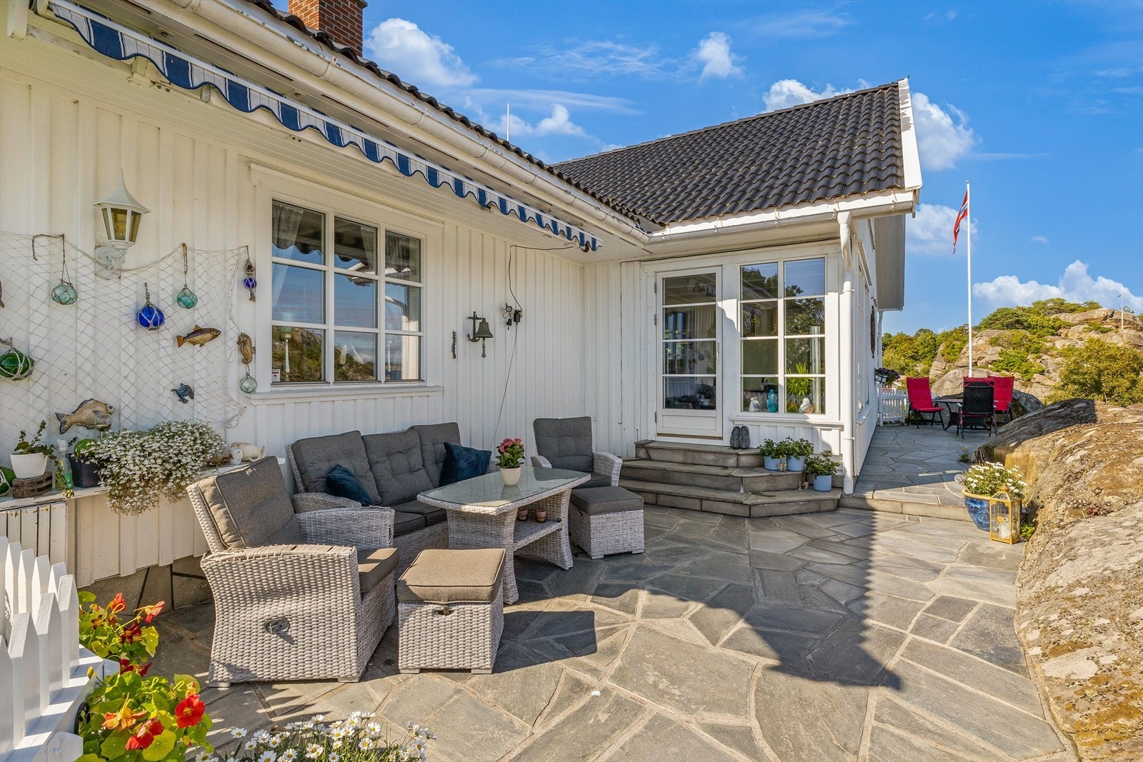 Utenfor stuen ligger en skiferkledd uteplass av god størrelse. Galleribilde