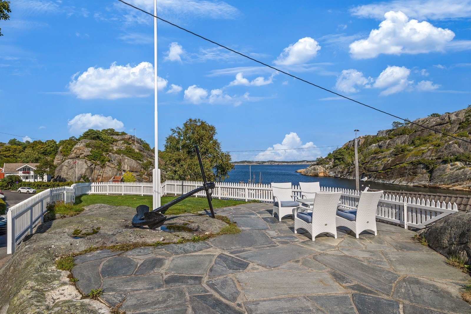 Ved siden av gårdsplassen ligger et skiferkledd uteareal med flaggstang og rom for møblement. Galleribilde