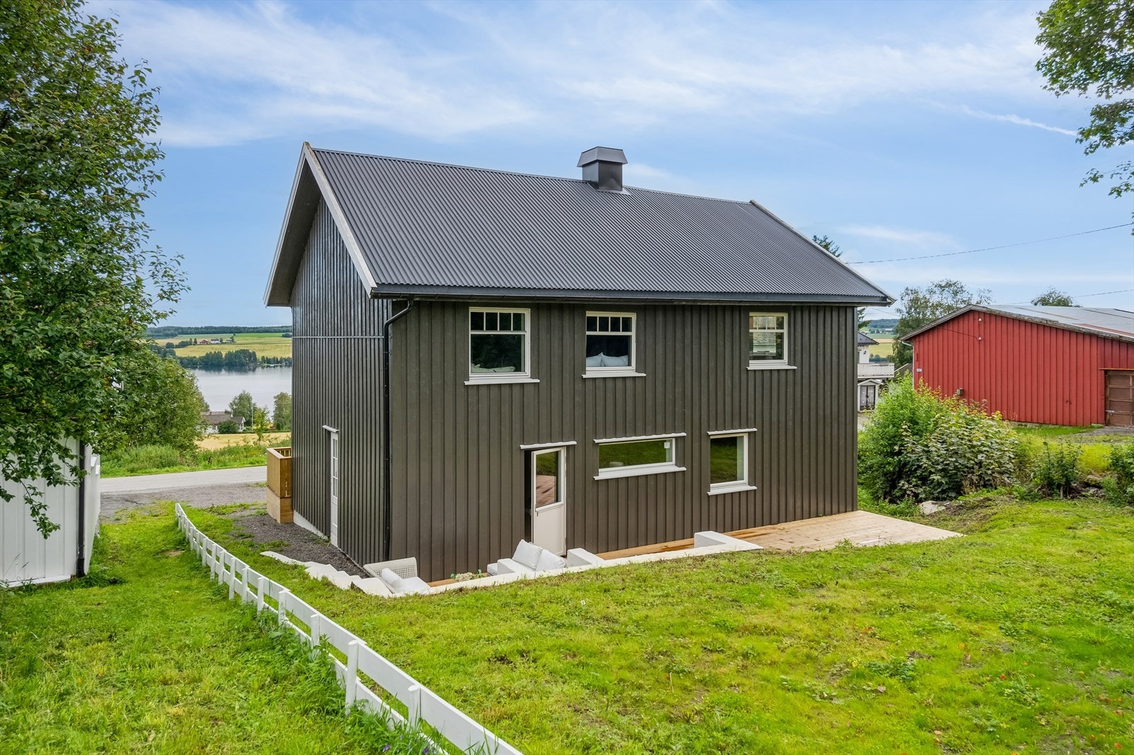 Tomten er opparbeidet med plen og beplantning. Galleribilde