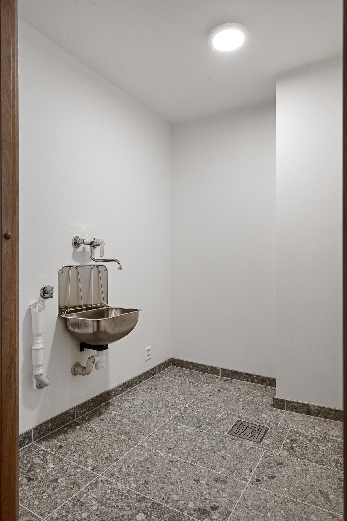 Vaskerom med fliser på gulv med sluk, samt utslagsvask. Avsatt plass til hyller og innredning gir deg gode muligheter for ordning och reda Galleribilde