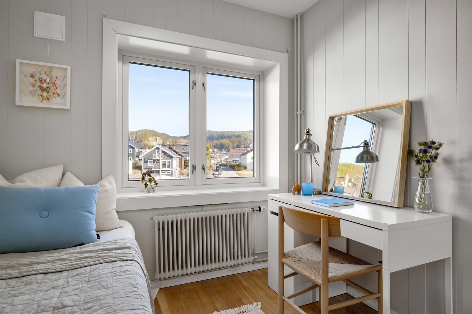 Rommet oppleves svært lyst og luftig med godt av lysinnslipp fra stort vindu sammen med lyse vegg og gulvflater med parkett Galleribilde
