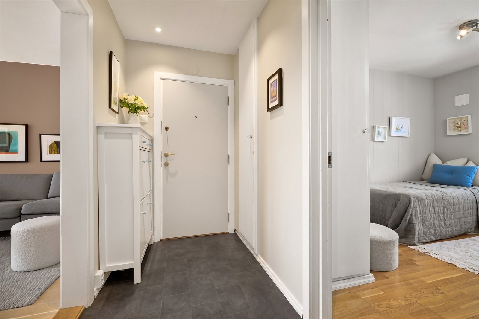 Lys og innbydende entré med lysmalte veggflater og gulvflater av praktisk laminat samt downlights i himling Galleribilde