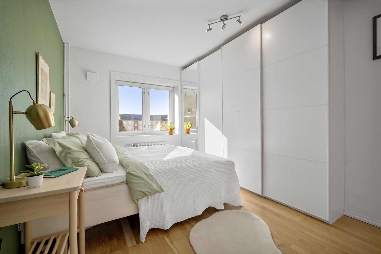 Veggflatene er malt i en lun tone og på gulvet er det lys parkett. Rommet er utstyrt med en romslig skyvedørsgarderobe med god lagringskapasitet Galleribilde