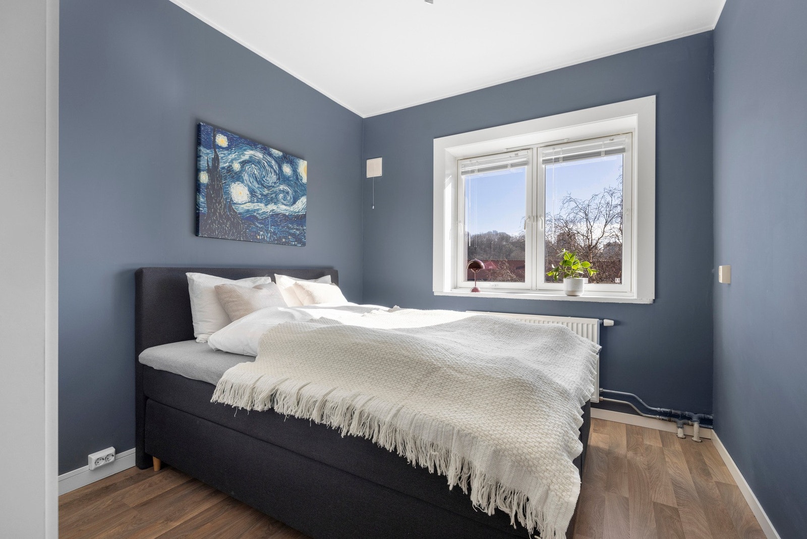 Det flommer inn med naturlig lys gjennom store vindusflater som skaper en lys og luftig atmosfære. Veggene er malt i en dyp blåfarge som inviterer til en god natts søvn. Galleribilde