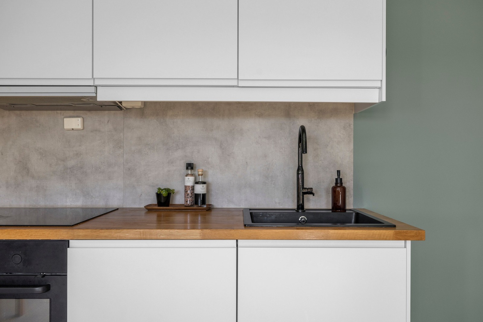 Benkeplaten er av laminat med vask i sort utførelse og ett greps kjøkken armatur. Mellom benkeplaten og overskapene er det en laminatplate. Galleribilde