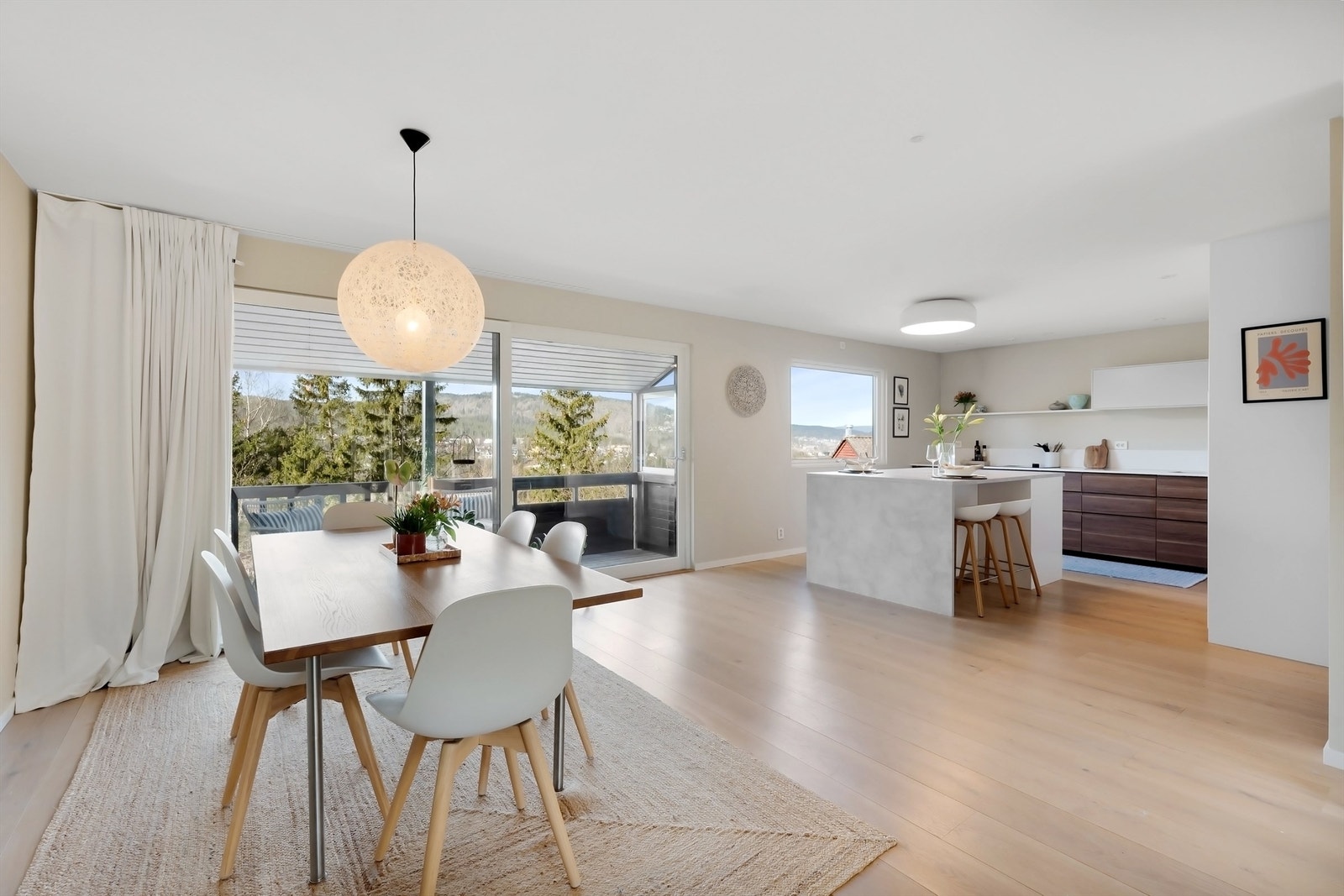 I åpen løsning mot stuen finner vi et delikat og stilrent kjøkken med en stor kjøkkenøy med barløsning Galleribilde