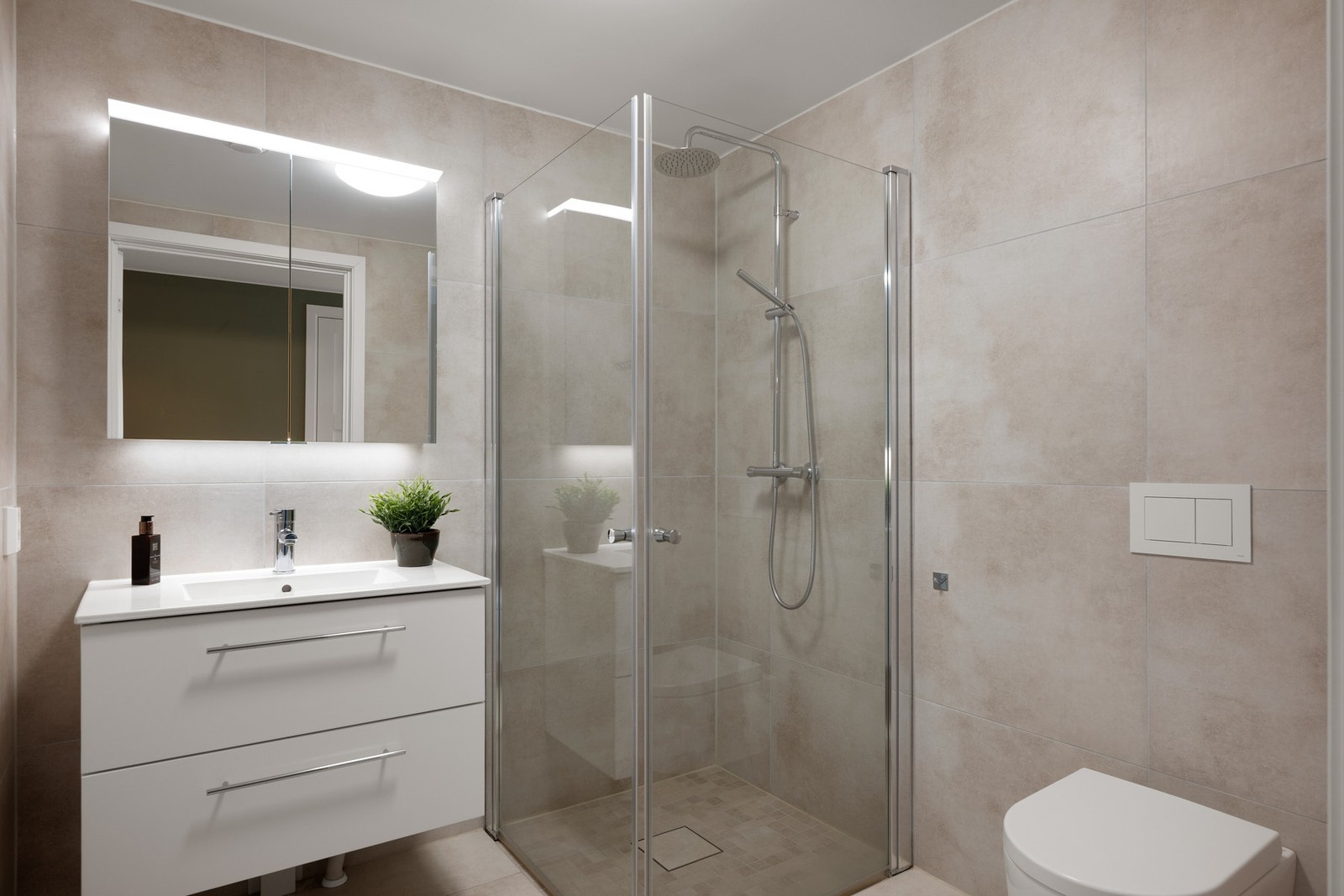 Lekkert og flislagt baderom med speilskap. Galleribilde