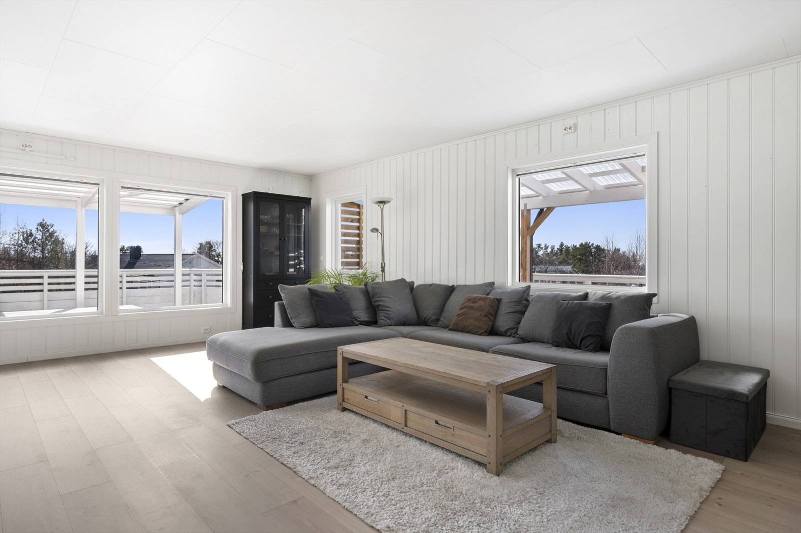 Innbydende dagligstue med store vinduer som slipper inn rikelig med naturlig lys. Galleribilde