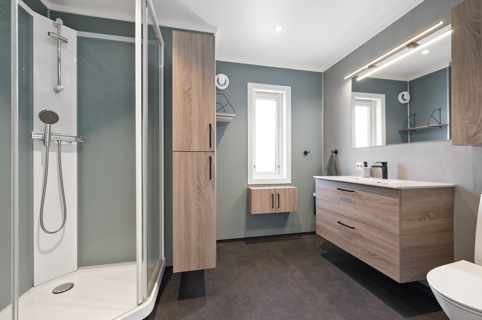 Meget innbydende bad med dusjkabinett, servant og WC. Galleribilde