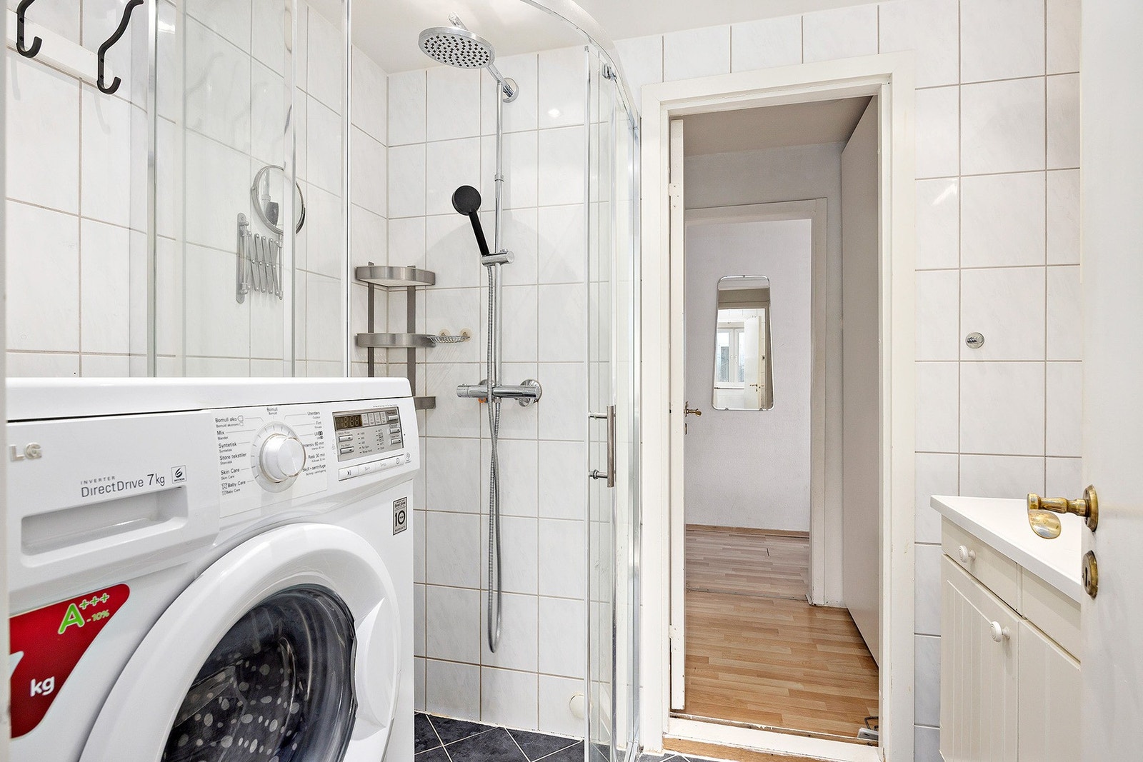 Badet er utstyrt med håndvask, overskap, dusjsone samt opplegg for vaskemaskin. Galleribilde